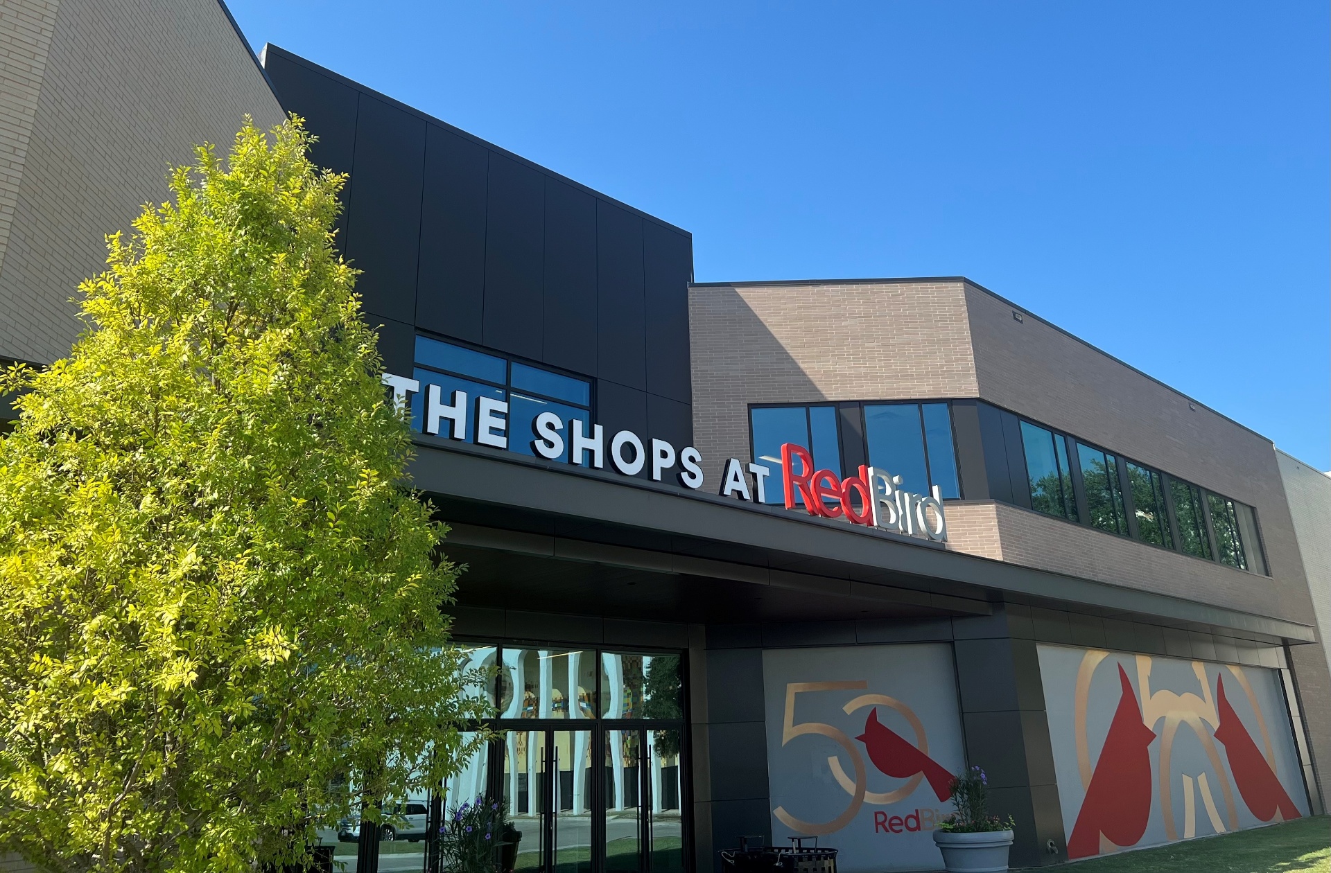 The Shops at Red Bird mall entrance with 50th anniversary cardinal mural